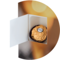 A golden praline in an open box with a colorful background